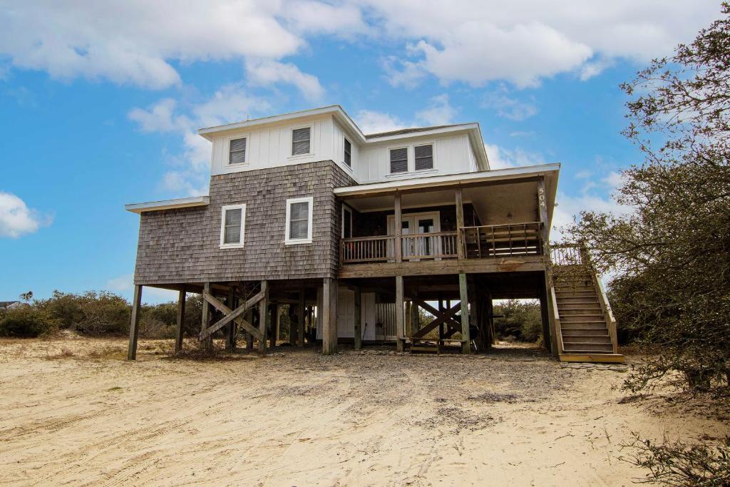 a house sitting on top of a beach at Oceanside, Hot Tub, Screened Porch, Wild Horses, 4x504, Sol Searcher in Corolla