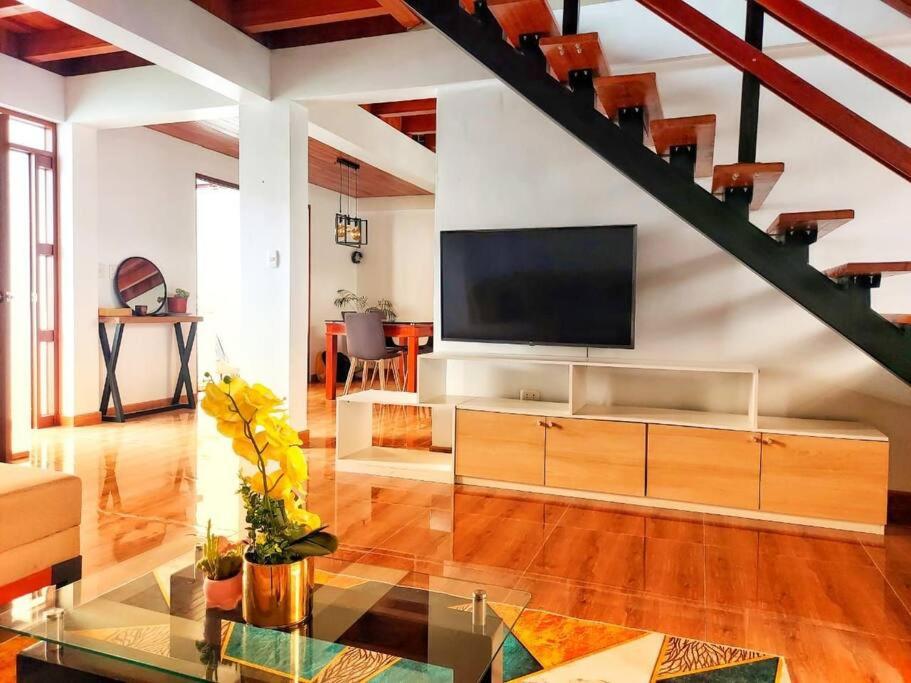 a living room with a flat screen tv on a wall at Casa Belgrado, te espera. in Oxapampa