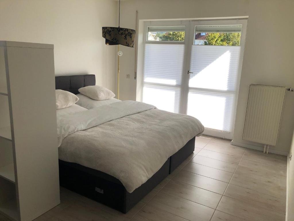 1 dormitorio con cama y ventana grande en Luxliv Apartements, en Balingen