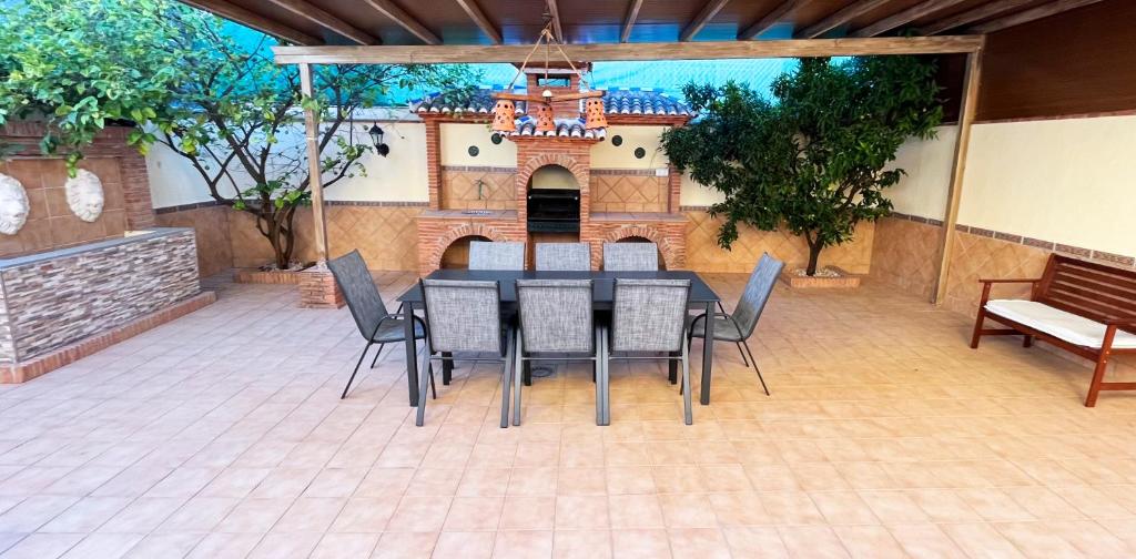 a dining table and chairs on a patio at VILLA ROSARIO entre Granada y Sierra Nevada in La Zubia