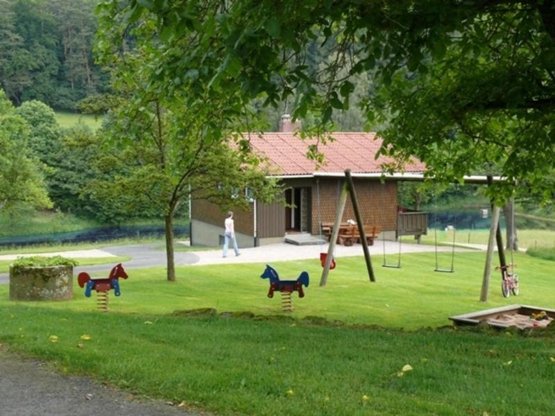 un parque infantil con tres caballos de juguete en la hierba en Ferienhauser Siefertshof, en Mossautal