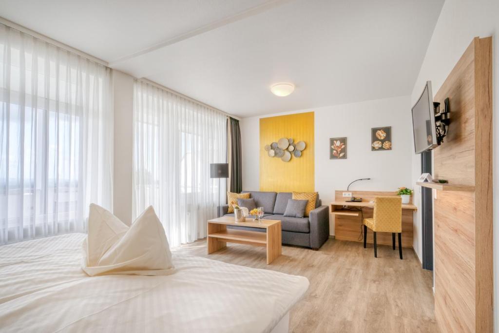 a hotel room with a bed and a living room at Hotel Wiehen-Therme in Hüllhorst