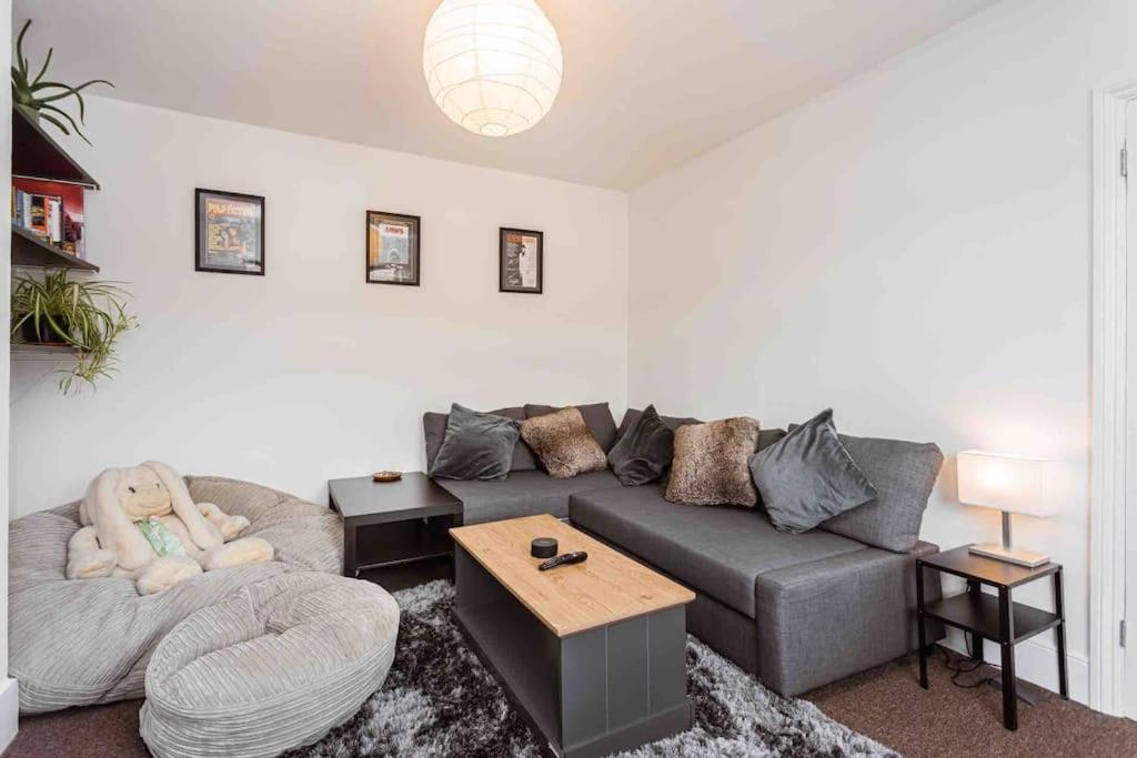 een woonkamer met een grijze bank en een tafel bij Lavender Lodge - Near Shops & with Free Parking in Haywards Heath