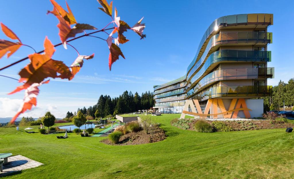 a building on a grassy field next to a building at Hotel AVIVA****s make friends 