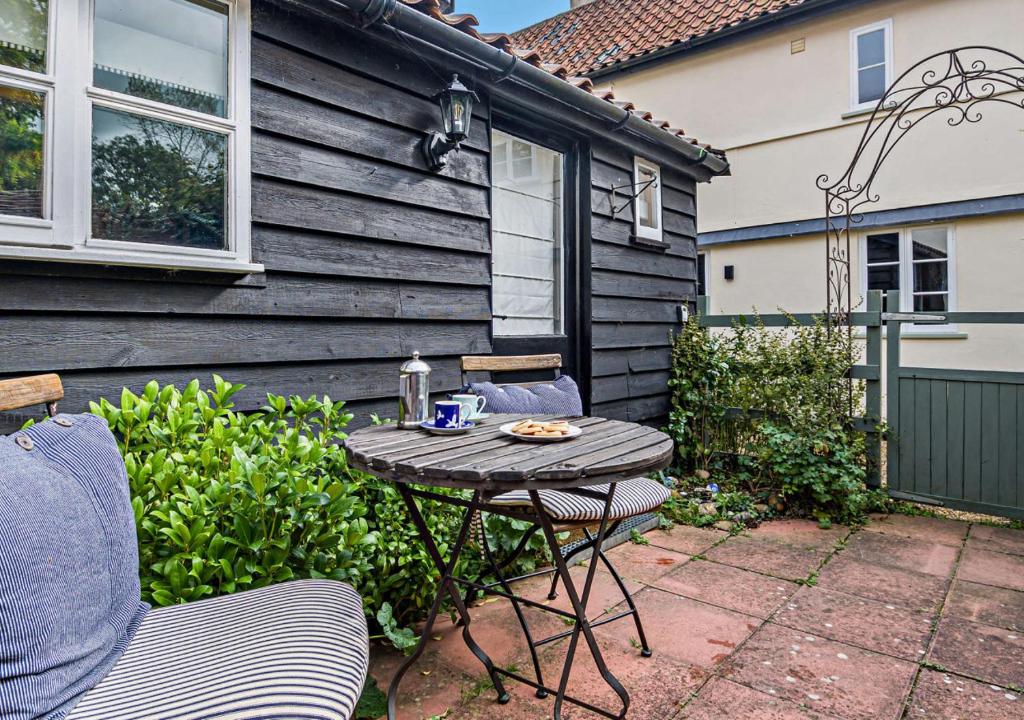 a small table and chairs in a yard with a house at No.36 Debenham in Debenham