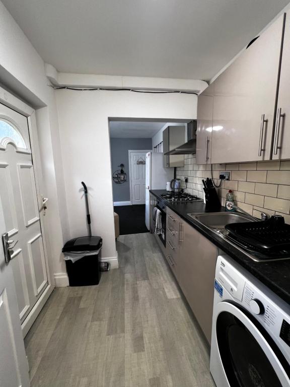 a kitchen with white cabinets and a counter top at Beautiful 1 Double Bedroom Flat Sheffield City Centre in Heeley