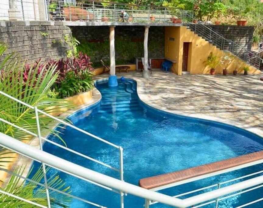a swimming pool in a yard with a house at Modern Studio/Apt overlooking Pool/Ocean view in San Juan del Sur