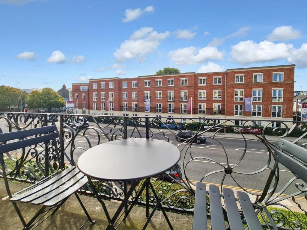 a table and chairs on a balcony with a building at Margaret's Terrace in Cheltenham