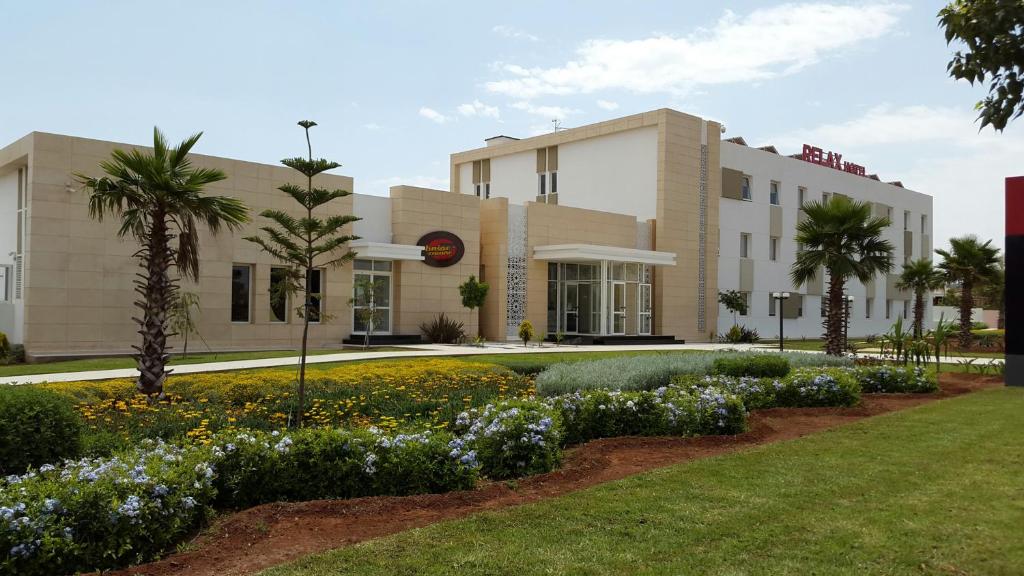 a building with a garden in front of it at Relax Hôtel Oujda in Oujda
