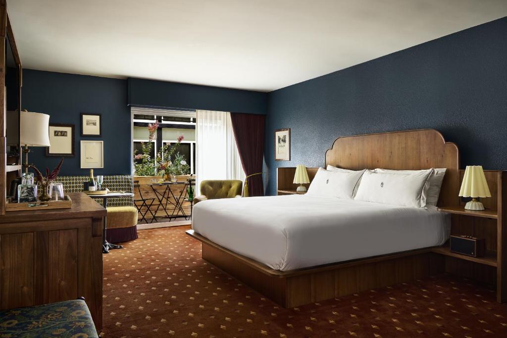 a bedroom with a large white bed and blue walls at The Hotel Chalet at The Choo Choo in Chattanooga