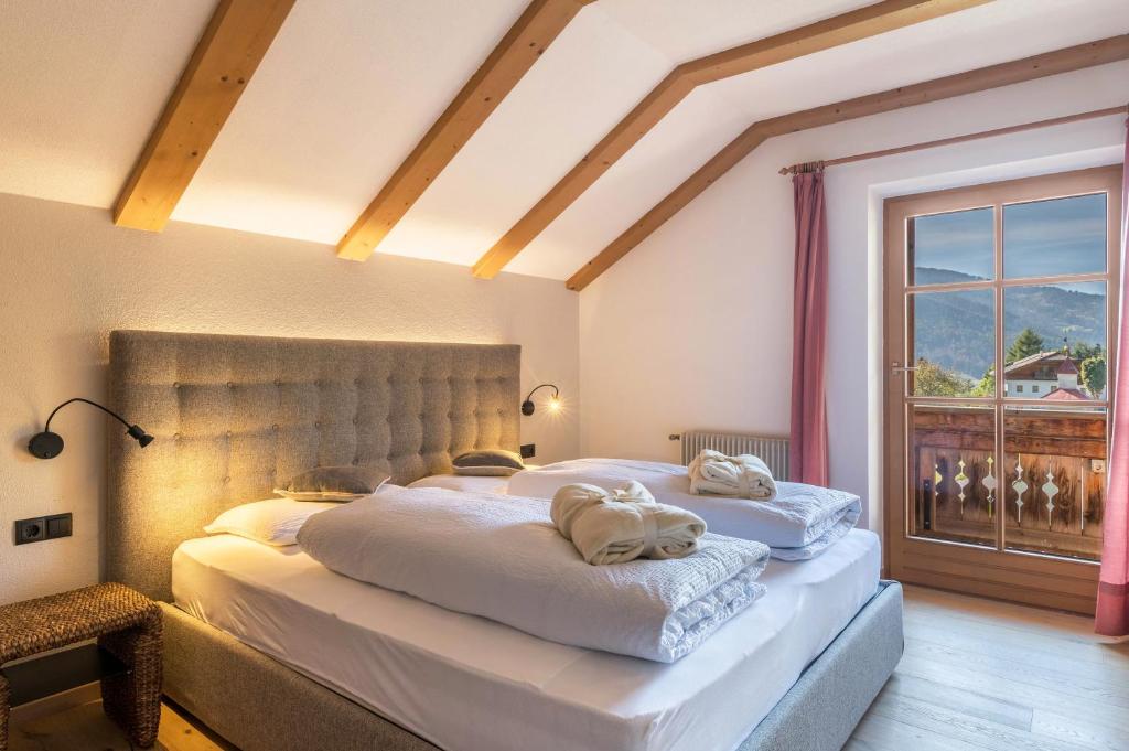een slaapkamer met 2 bedden en handdoeken bij Häuslerhof App Tilia in Villabassa