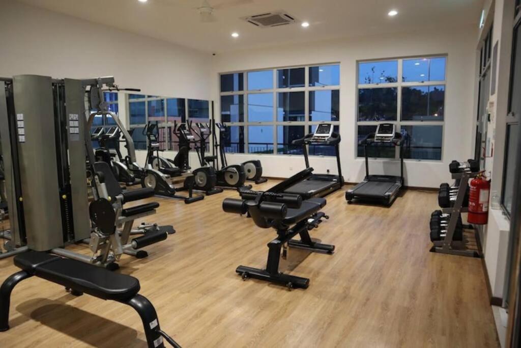 a gym with several treadmills and machines in a room at RatuSpaQ Home Desaru Utama Residence Apartment in Bandar Penawar
