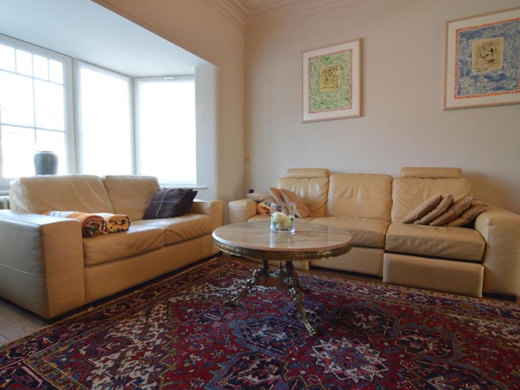 uma sala de estar com um sofá e uma mesa em Lavish Villa in Middelkerke with Sauna em Middelkerke