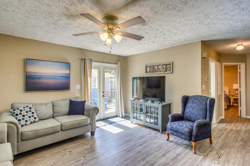 ein Wohnzimmer mit Sofa und Fernseher in der Unterkunft North Carolina Abode - Deck and Grill, Walk to Beach in Oak Island