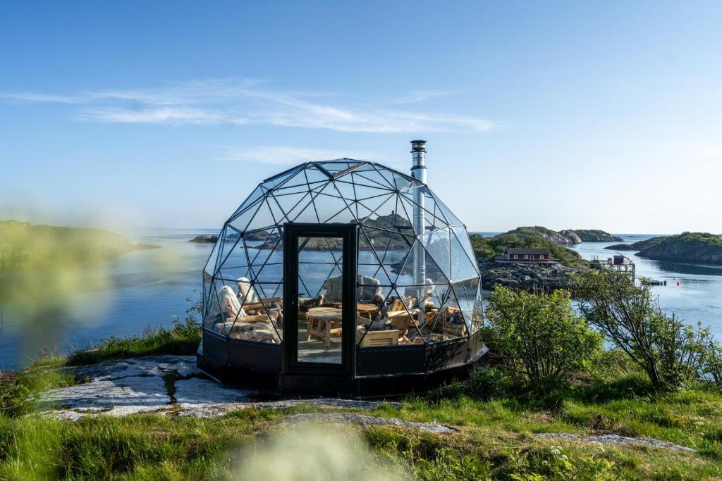 een glazen koepel op een heuvel bij het water bij Lofoten Island Lodge in Henningsvær