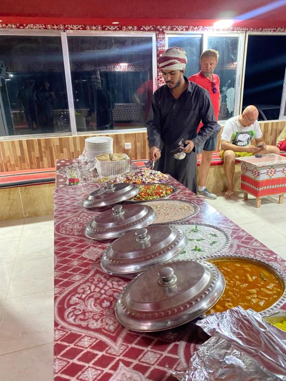 a man standing in front of a table with dishes at Rest luxury camp in Disah