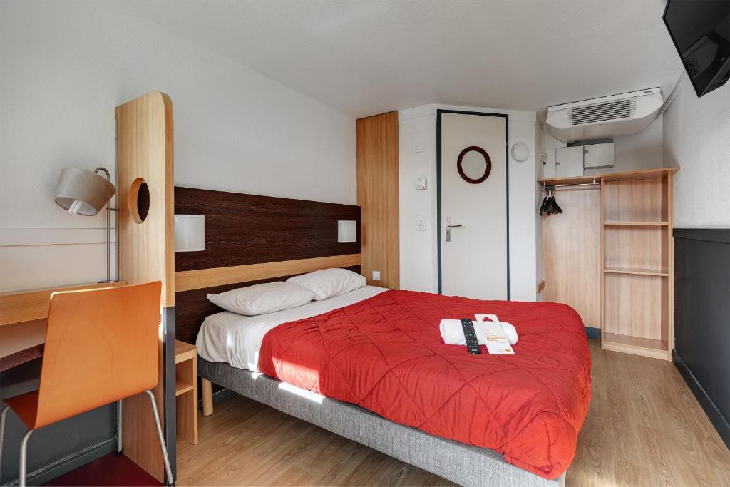 a bedroom with a bed with a red blanket and a desk at Premiere Classe Bethune Fouquières Lès Béthunes in Fouquières-lès-Béthune