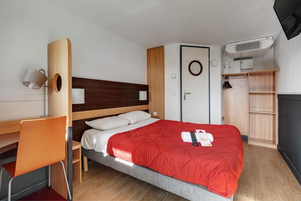 a bedroom with a bed with a red blanket and a desk at Premiere Classe Bethune Fouquières Lès Béthunes in Fouquières-lès-Béthune