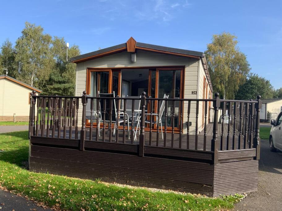 a tiny house with a porch and a balcony at Country Gem in Tydd Saint Giles