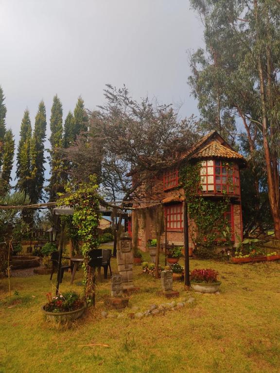 a small house in a field with a garden at Tu Casa - Hotel Rural in Sopó