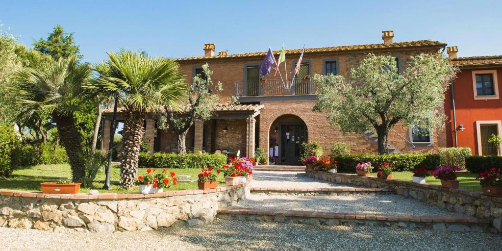 ein Haus mit Blumen und Pflanzen davor in der Unterkunft ISA-Il Casale di Donoratico, Residence with swimming pool just 5 minutes from the beach of Marina di Castagneto in Donoratico