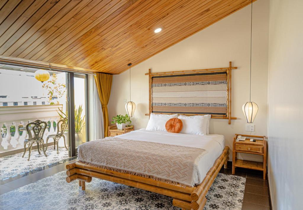 een slaapkamer met een groot bed en een balkon bij Virgo Villa Quê Hội An in Hội An