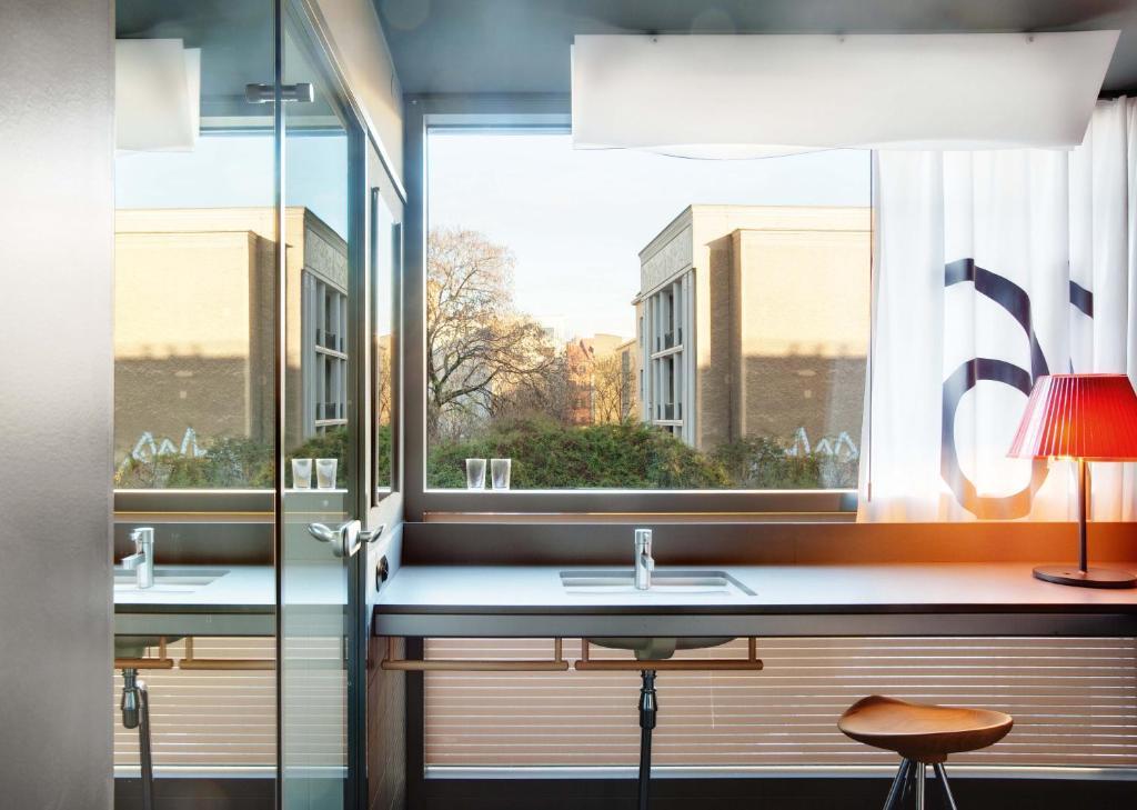 a bathroom with two sinks and a large window at Casa Camper Berlin in Berlin