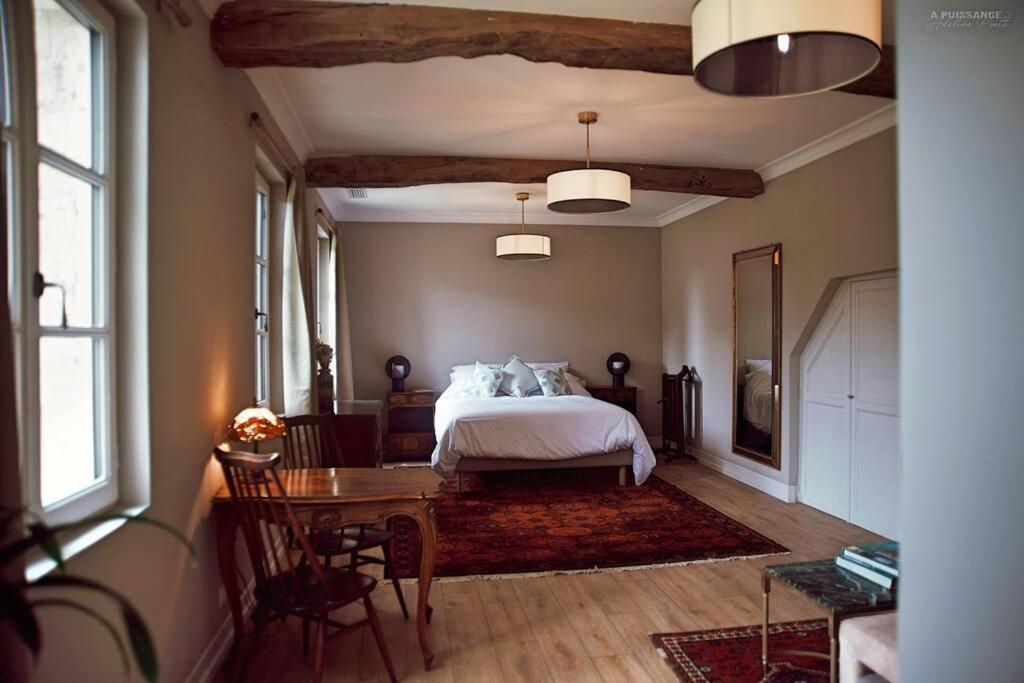 Rouffignac-de-SigoulèsにあるChâteau Le Repos - Luxury air-conditioned property with poolのベッドルーム1室(ベッド1台、テーブル、椅子付)
