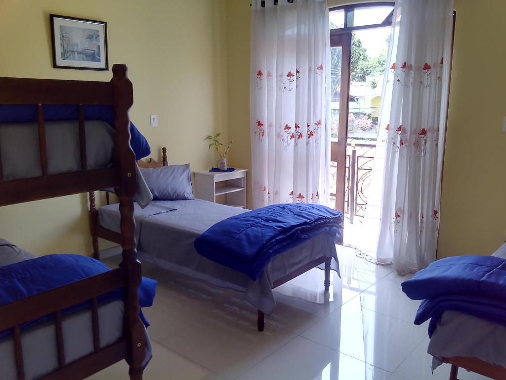 a bedroom with two bunk beds and a sliding glass door at Suíte para 4 pessoas - CE - 2 km Autódromo de Interlagos in Sao Paulo