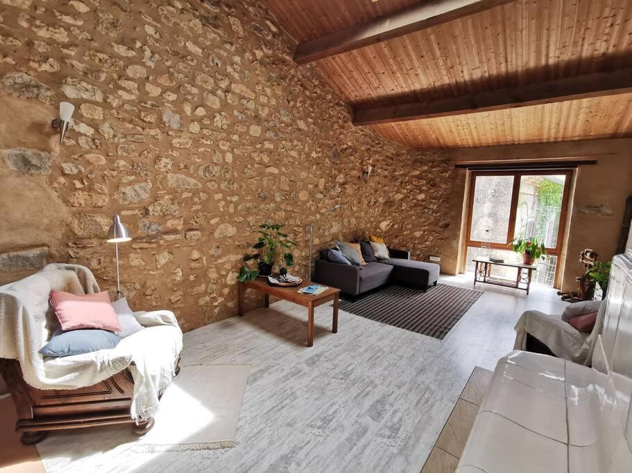 a living room filled with furniture and a stone wall at Le gîte sylvestre, maison rurale in Saint-Jean-de-Paracol