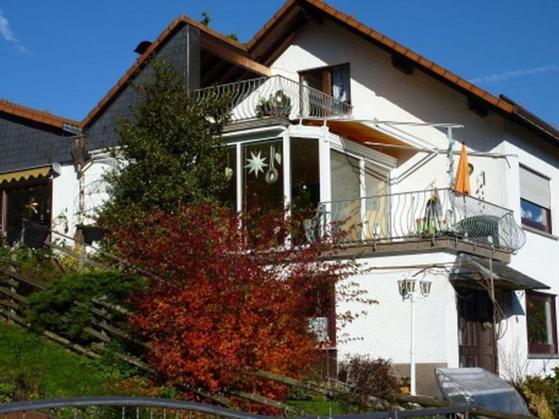 ein weißes Haus mit Balkon darüber in der Unterkunft Ferienwohnung Koenig in Wald-Michelbach