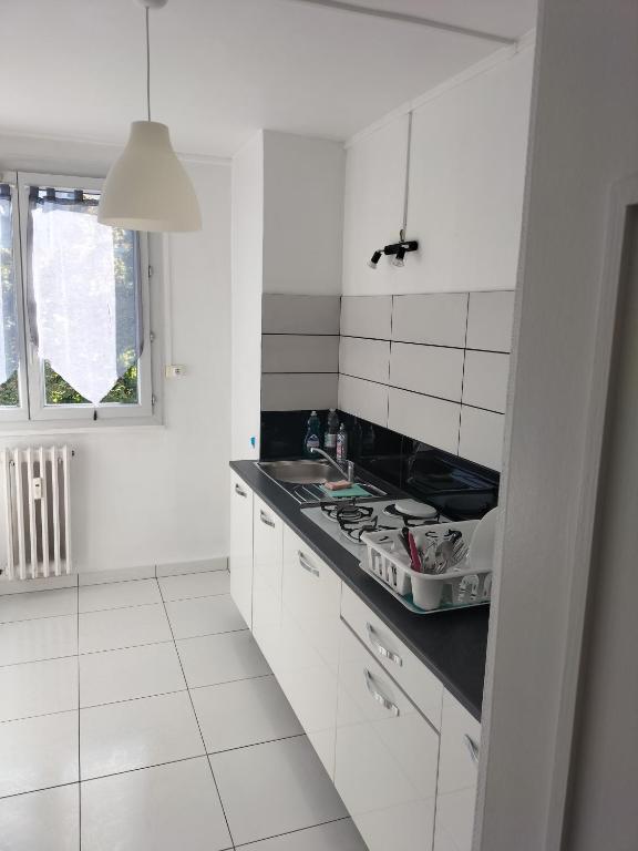 a white kitchen with a stove and a sink at Joli appartement proche métro in Lyon