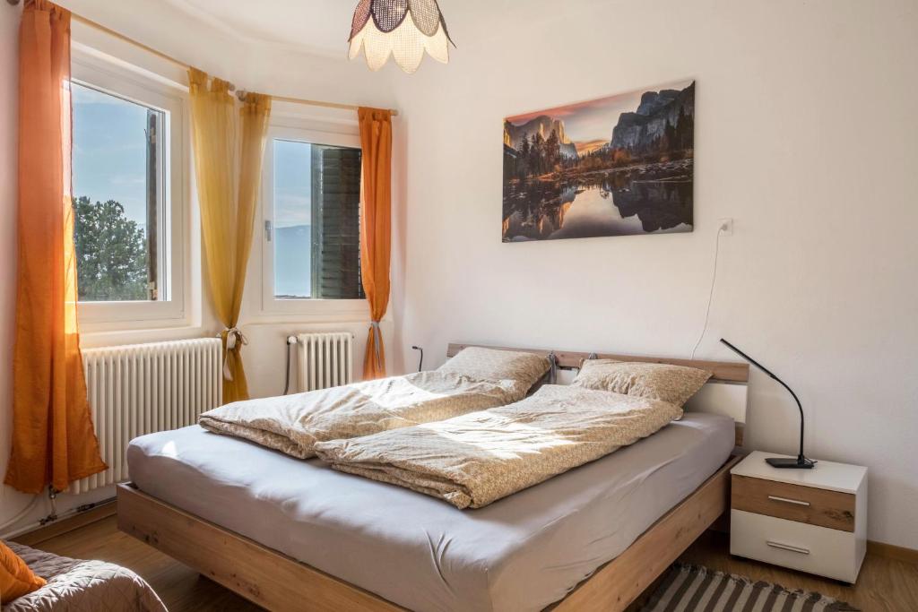 a bedroom with a bed and two windows at Ferienhaus Weingut Plonerhof in Bolzano