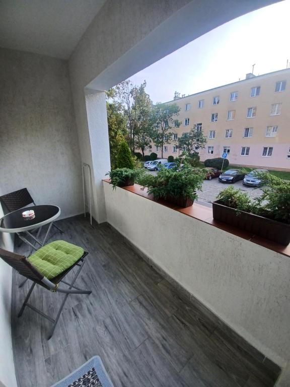 Un balcón con una silla y una mesa y un edificio en Apartament LORD en Toruń