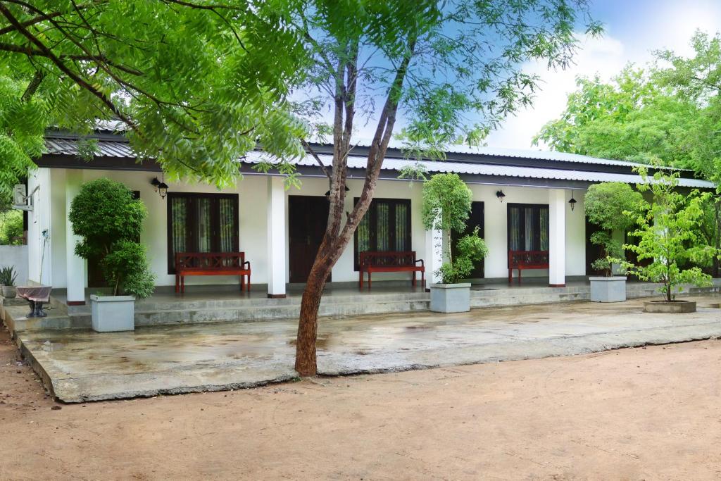 a white building with red benches in front of it at Flying Peacock Yala, Katharagama, in Kataragama