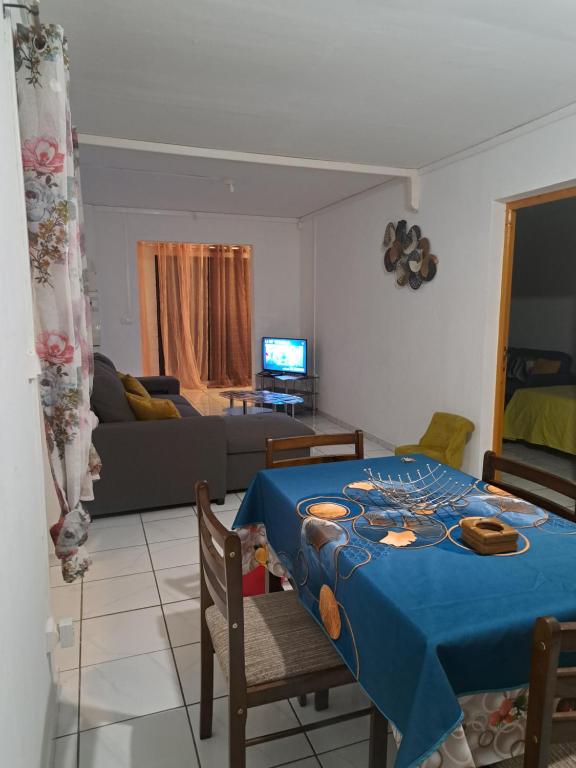 sala de estar con mesa azul y sofá en Appart a la res ANDY accueillant 1 A 5 PERS arrivé autonome , 2 PLACES de parking dans la cour devant la maison, en Saint-Denis