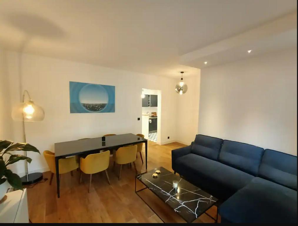 un salon avec un canapé bleu et une table dans l'établissement Brand new flat - Really calm in Central Paris, à Paris