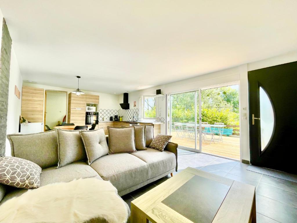 un salon avec un canapé et une table dans l'établissement 2 Maisons - Le Tranquille - Jardin - Terrasse - BBQ, au Mans