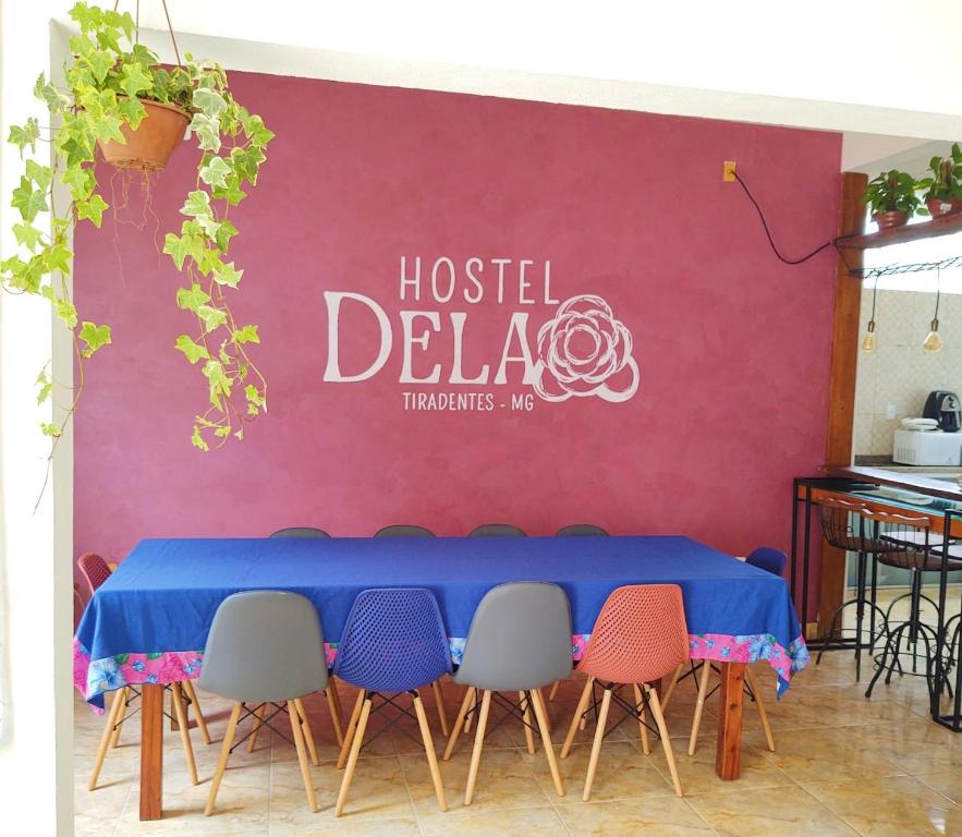 una mesa con sillas y un cartel que lee "hostel delia" en Hostel Dela, en Tiradentes
