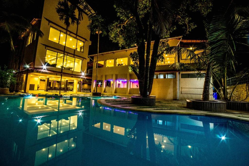 a swimming pool in front of a building at night at Amansaraa Bhide Retreat in Kīhīm