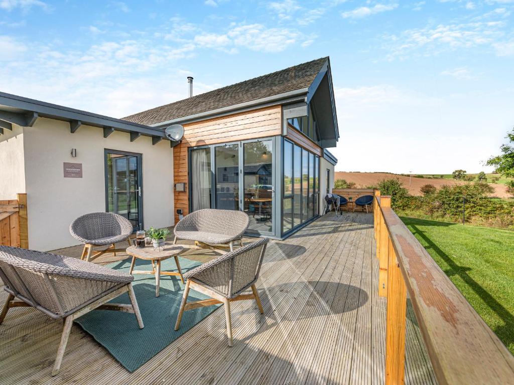 a patio with chairs and a table on a deck at Shearwater Lodge in Bamburgh