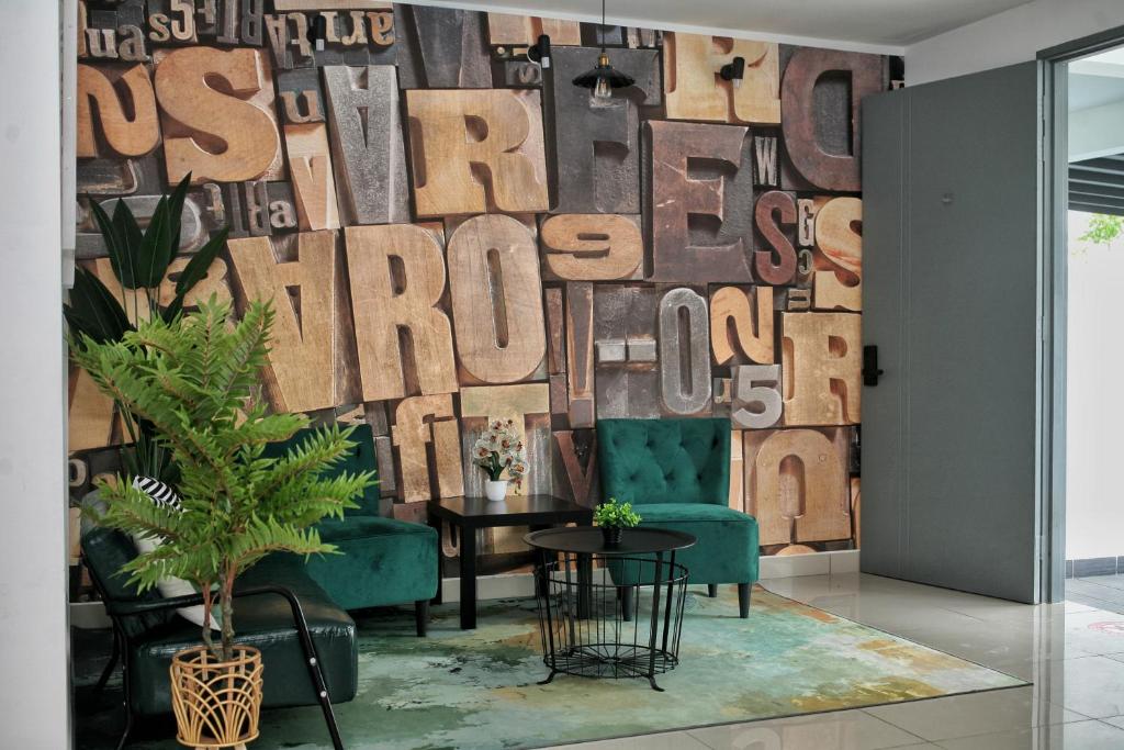 a living room with a wall covered in wooden letters at Homestay Desaru Rock House in Bandar Penawar