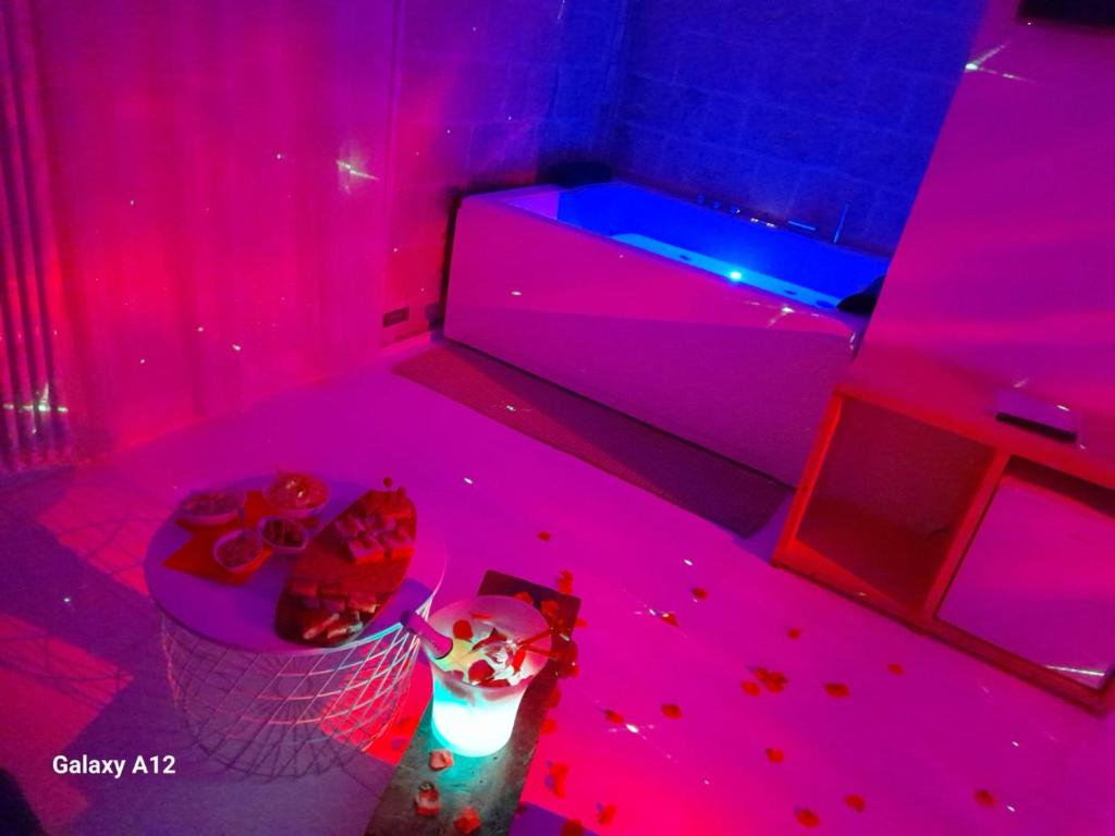 una camera con luci rosa e blu e una vasca di Recinto antico Sweet Rooms a Matera