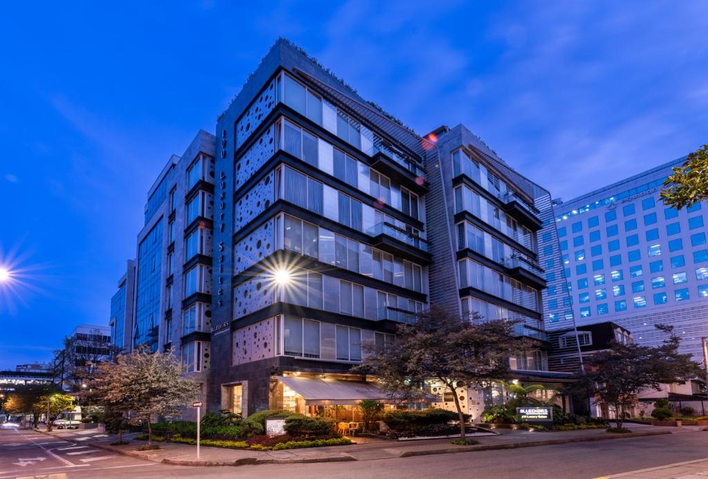 un edificio de oficinas con ventanas de cristal en una calle de la ciudad en Hotel 100 Luxury Suites by Preferred, en Bogotá