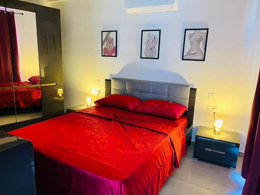 - une chambre avec un lit rouge et deux lampes dans l'établissement SinSea Penthouse, à San Pawl il-Baħar