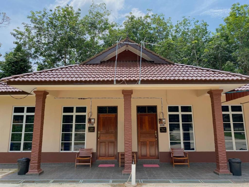 uma pequena casa com um telhado vermelho em NSJay Guest House em Kampong Gong Balai