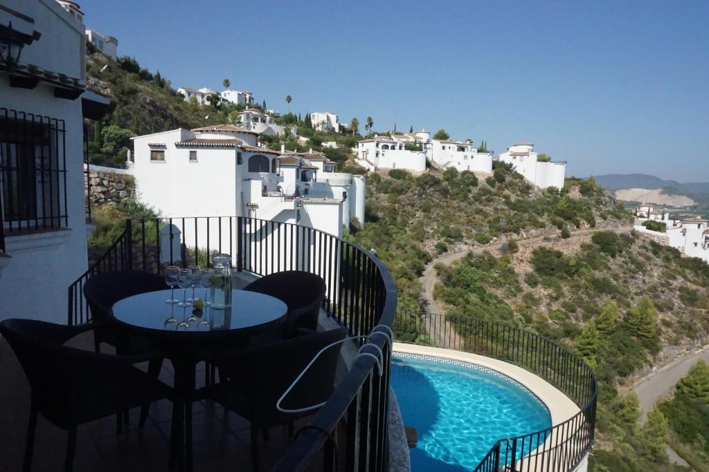 a balcony with a table and chairs next to a swimming pool at Los Tulipanes in Pego