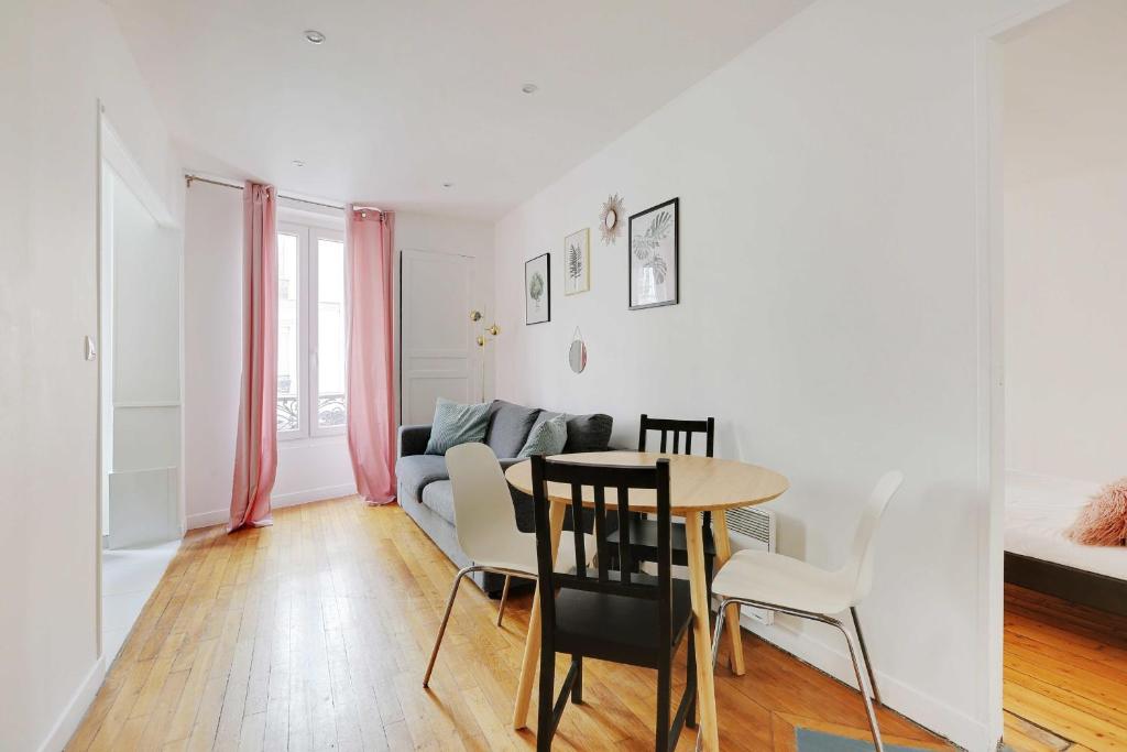 un salon avec une table et un canapé dans l'établissement Charming appartement - 1BD-4P - Batignolles, à Paris