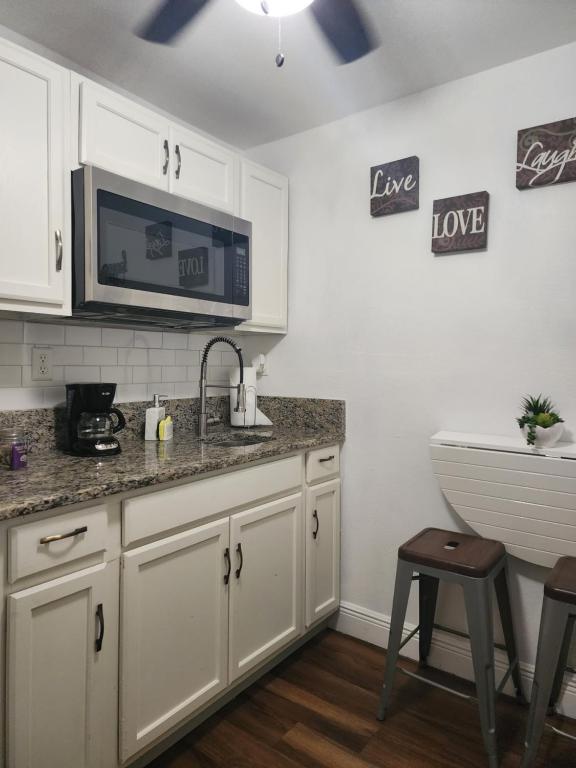 a kitchen with white cabinets and a sink and a microwave at Diamond 2 in Tampa
