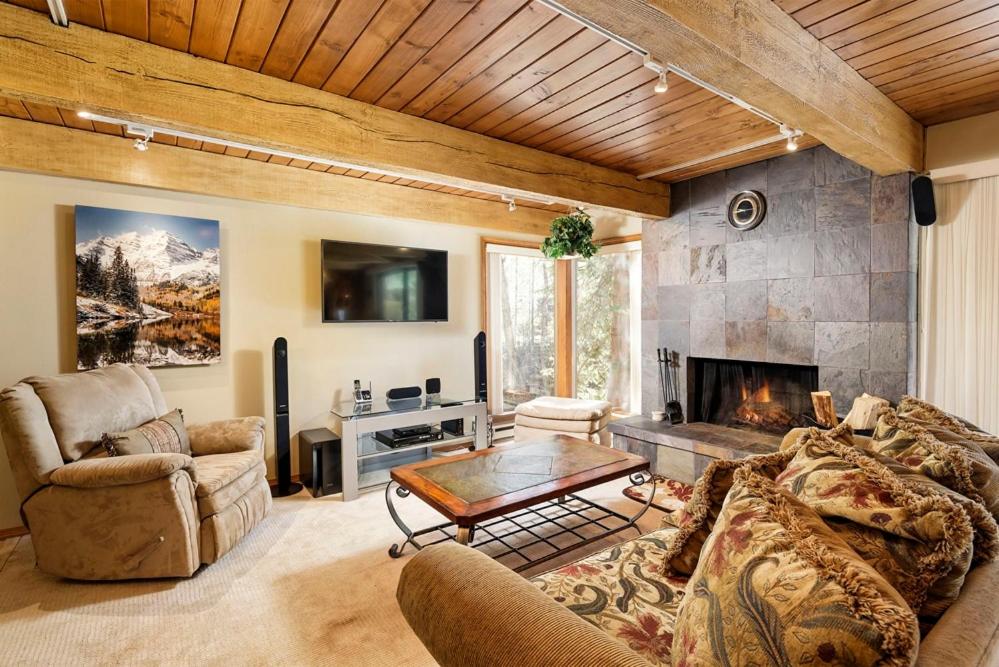 uma sala de estar com um sofá e uma lareira em Chateau Eau Claire Unit 17, Serene Condo Overlooking the River with Many Upgrades em Aspen